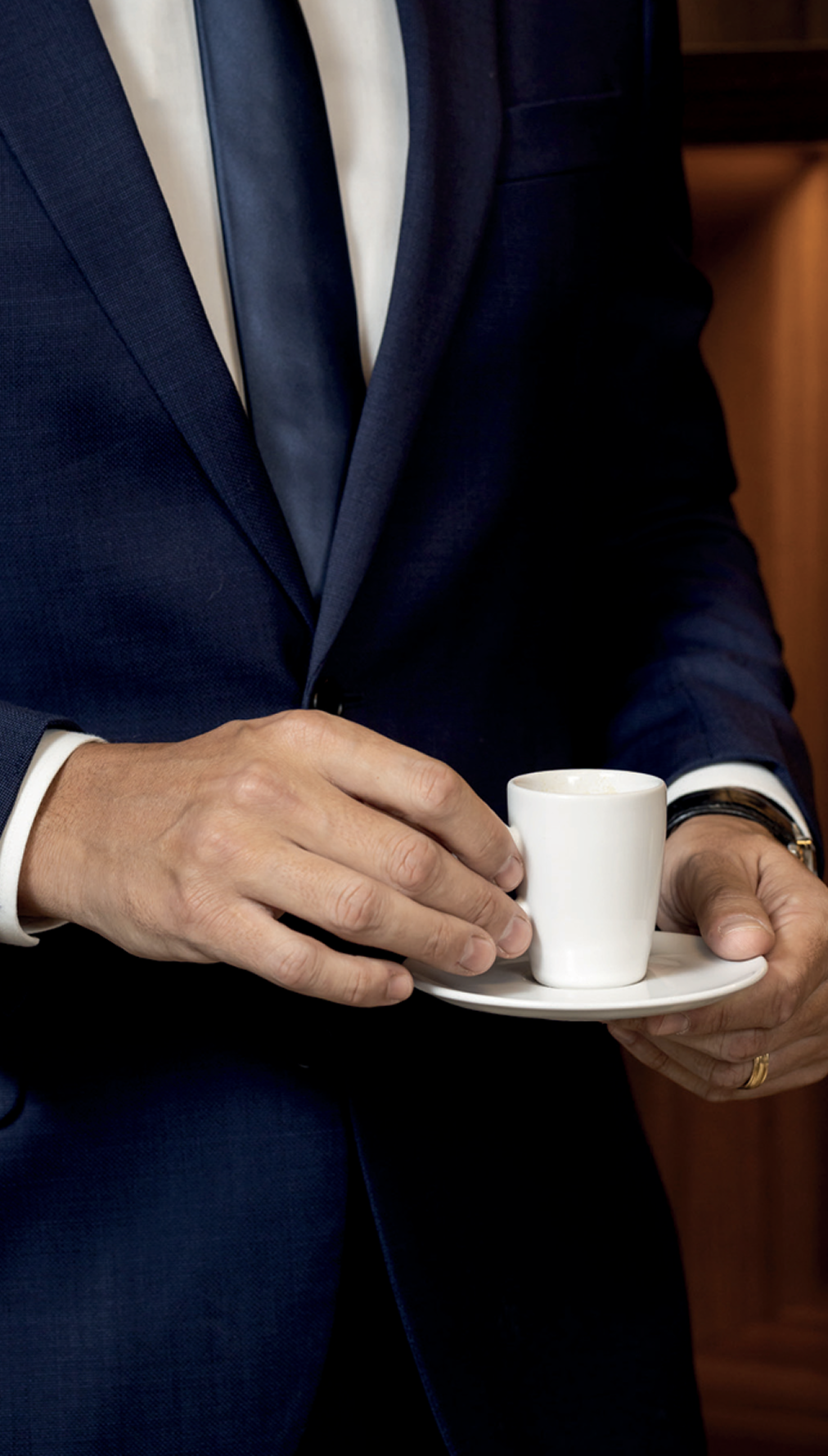 Profissional de terno segurando uma xícara de café
